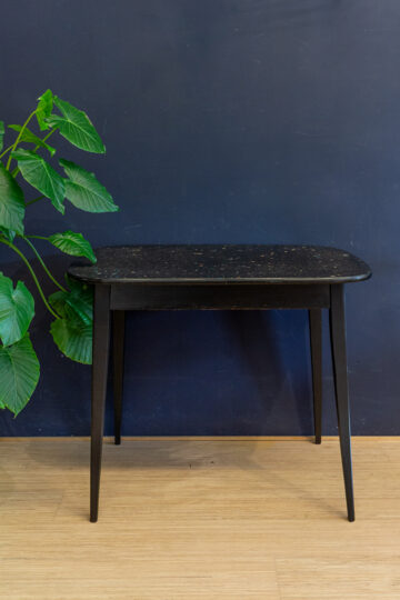 Vintage zwarte eettafel met gekleurd confetti blad