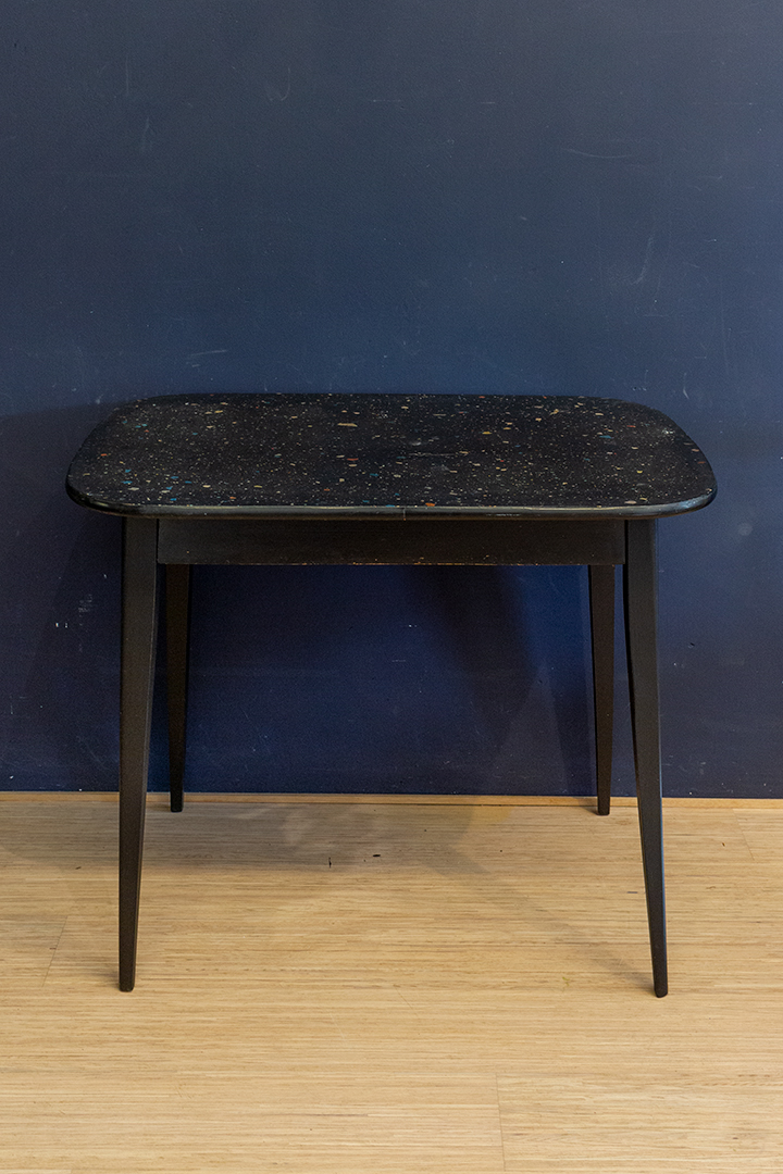 Vintage zwarte eettafel met gekleurd confetti blad